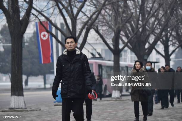 People walk on a street outside Pyongyang Department Store No. 1 on the 83rd birth anniversary of late North Korean leader Kim Jong Il in Pyongyang...