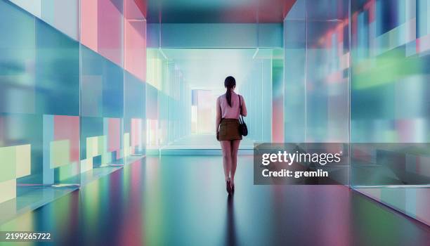 young woman walking in futuristic glass corridor - tunnel stockfoto's en -beelden