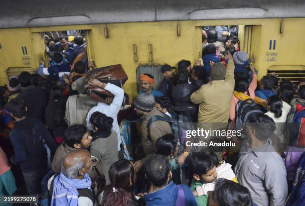 Passengers jostle with each other to board a train at the New Delhi Railway station, in New Delhi, India on February 16, 2025. At least 18 people...