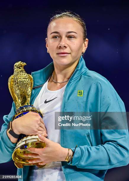 Amanda Anisimova of the United States poses with the trophy after defeating Jelena Ostapenko of Latvia during the WTA Qatar TotalEnergies Open 2025...