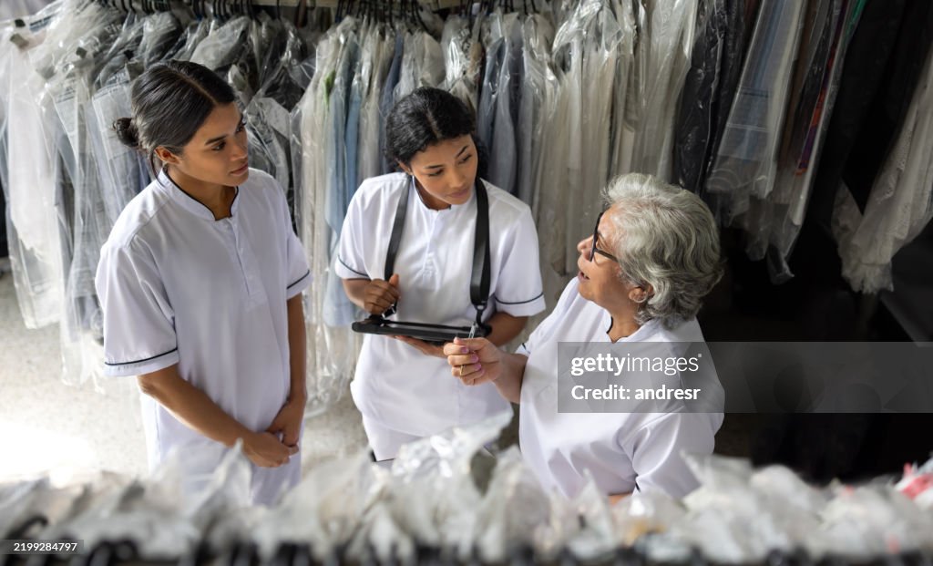 Business owner training new employees at an industrial laundry