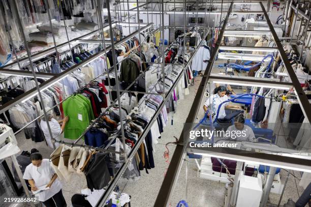 employees working at the dry cleaner - dry cleaning bag stock pictures, royalty-free photos & images