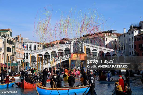 Revellers parade on boats sailing on the Grand Canal in front of Rialto bridge during Venice Carnival, on February 16, 2025. This year, the theme of...