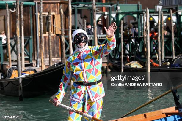 Man dressed as Arlequin waves from is boat during a parade on the Grand Canal at Venice Carnival, on February 16, 2025. This year, the theme of one...