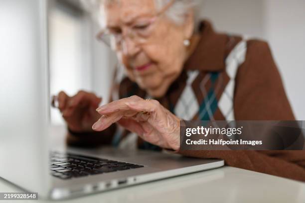 close up of senior woman using laptop on her own, doing online banking, paying bills. - invecchiamento della popolazione foto e immagini stock