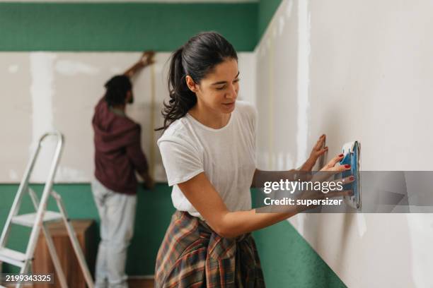 tarea colaborativa: hombre y mujer trabajando juntos - renovación del hogar fotografías e imágenes de stock