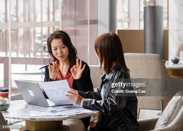 a business woman talking with ai translator app in smartphone - übersetzung stock-fotos und bilder