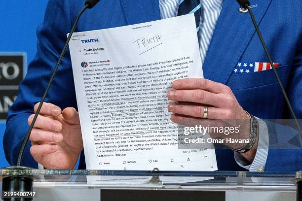 Secretary of Defence Pete Hegseth shows a sheet of paper with a document containing a summary of President Trump's conversation with Vladimir Putin...