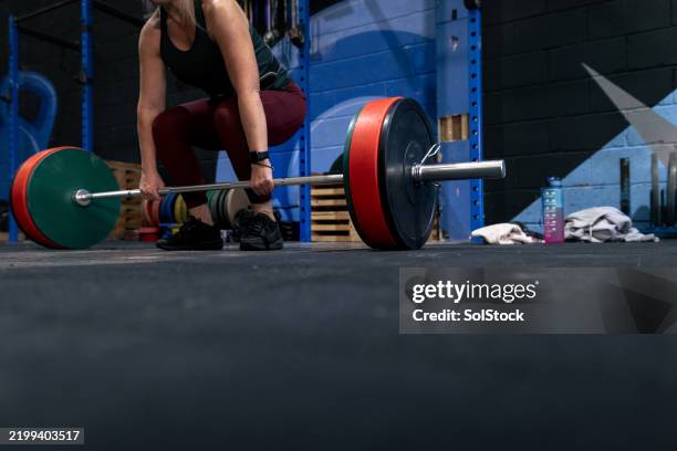 woman preparing to deadlift at the gym - medium shot stock pictures, royalty-free photos & images