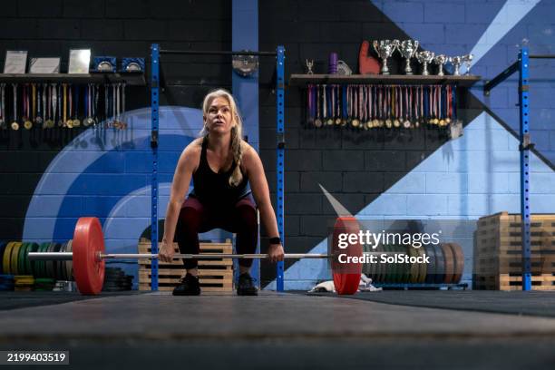 strong woman preparing to deadlift a barbell - barbell stock pictures, royalty-free photos & images
