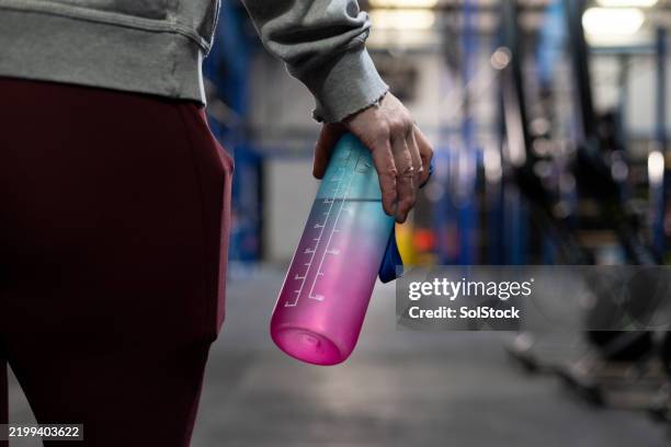 staying hydrated at the gym - female hand holding water bottle stock pictures, royalty-free photos & images