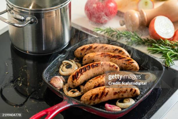 cooking sausages in a grill pan at home - pork sausage stock pictures, royalty-free photos & images