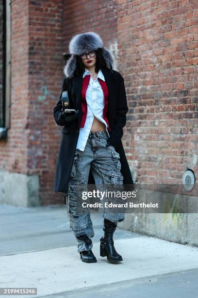 Guest wears silver faux fur trapper hat, white buttoned up long sleeve shirt, dark red cropped jacket, black wool coat, shiny black leather bag,light...