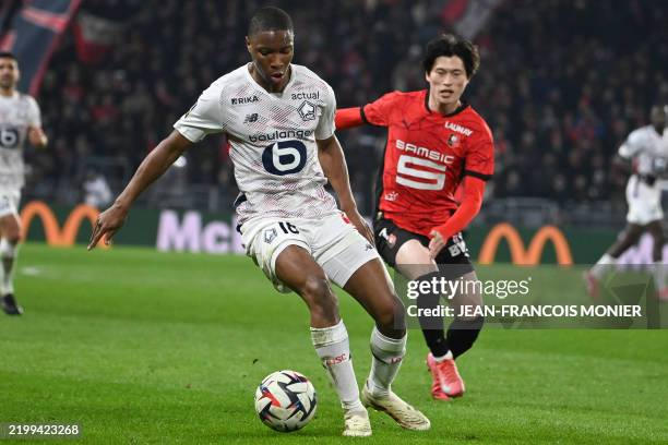 Lille's French defender Bafode Diakite fights for the ball with Rennes' Japanese Forward kyogo Fuhuashi during the French L1 football match between...