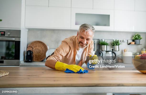 homme mûr nettoyant sa maison - chambre bien rangée photos et images de collection