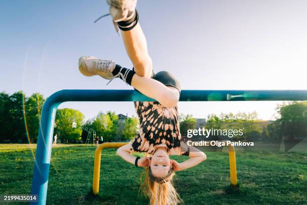 child hanging upside down - al revés posición descriptiva fotografías e imágenes de stock