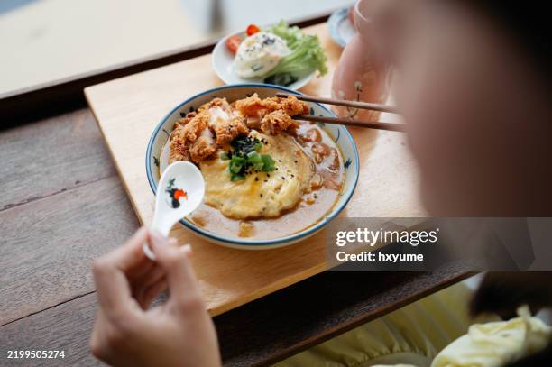asian woman eating japanese katsu curry rice in restaurant - japanese curry stock pictures, royalty-free photos & images