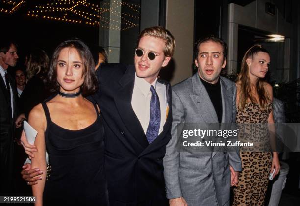 American actress and photographer Lisa Marie Kurbikoff, wearing a sleeveless black scooped-neck dress with a black-and-grey choker, and her partner,...