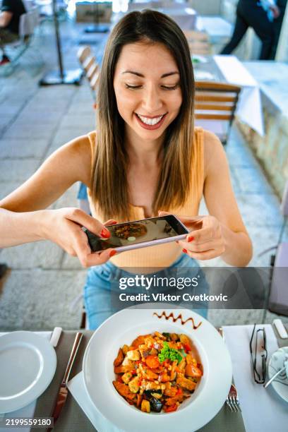 young woman taking photo of her meal in dubrovnik restaurant - blogging stock pictures, royalty-free photos & images