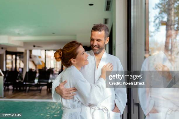 serene getaway: couple relaxing by the poolside window in a luxury spa - spa treatment stock pictures, royalty-free photos & images