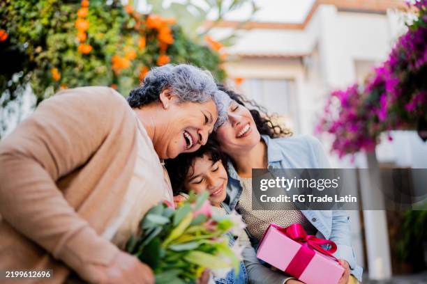 la famiglia abbracciata e con i regali all'aperto - festa della mamma foto e immagini stock
