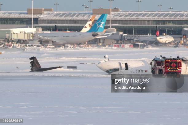 Flight 4819 from Minneapolis is seen overturned on the runway after crashing while landing at Pearson International Airport in Toronto, Canada on...