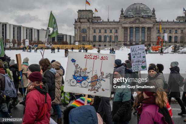 Marchers encircle the Bundestag Parliament building as supporters of the Fridays for Future climate action movement march in a climate strike on...