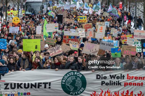 Marchers encircle the Bundestag Parliament building as supporters of the Fridays for Future climate action movement march in a climate strike on...