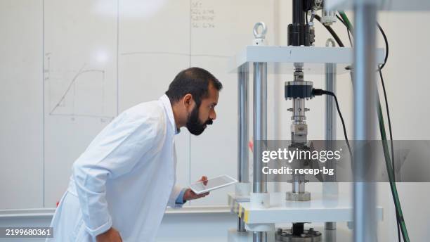 joven científico masculino étnico trabajando en laboratorio - química fotografías e imágenes de stock