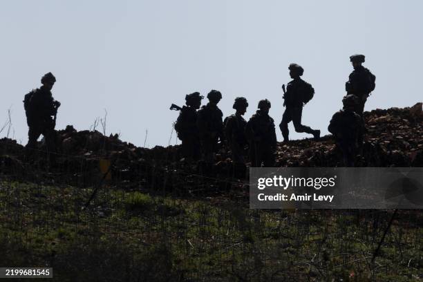 Israeli soldiers walk at the buffer zone between Northern Israel and Southern Lebanon as seen from a position on the Israeli side of the border on...