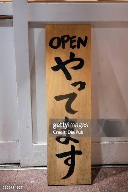 bilingual 'open' sign at night in yurakucho - open segnale inglese foto e immagini stock