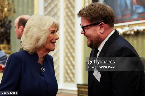 British Queen Camilla speaks with actor James Corden, as she attends a reception for staff, actors and supporters of the National Theatre at...
