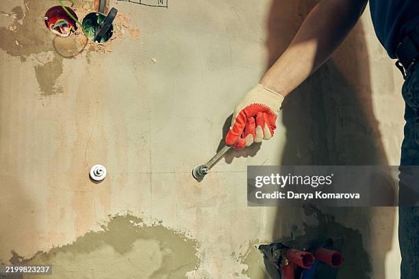 a man is screwing on the bolts for the bathroom sink. - handwerker bad stock-fotos und bilder