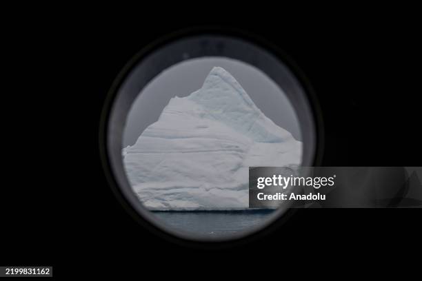 The huge glaciers are seen through a porthole, a watertight round window with shatterproof glass cut into the sides and decks to illuminate the...