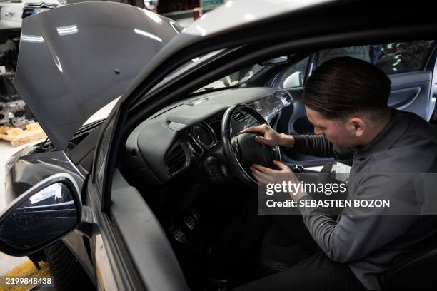 Mechanic installs a new airbag module in a car after removing an airbag module made by the Japanese airbag manufacturer Takata, in a garage in...