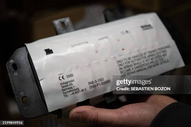 Mechanic holds an airbag module made by the Japanese airbag manufacturer Takata, in a garage in Mulhouse, eastern France, on February 19, 2025. Some...