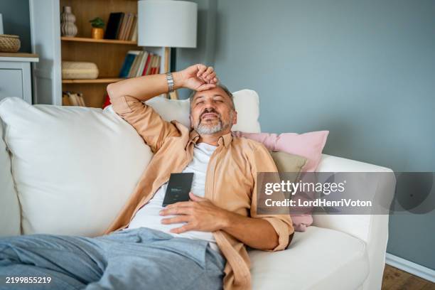 tired man falling asleep on the sofa - bored man stock pictures, royalty-free photos & images