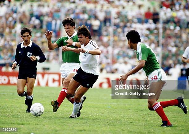 Klaus Allofs of West Germany is tackled by Rafael Amador of Mexico during the FIFA World Cup Finals 1986 Quarter Final match between West Germany and...