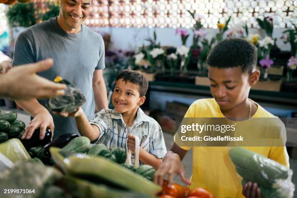 young boys choosing organic vegetables at the local market - mercado de produtos agrícolas imagens e fotografias de stock