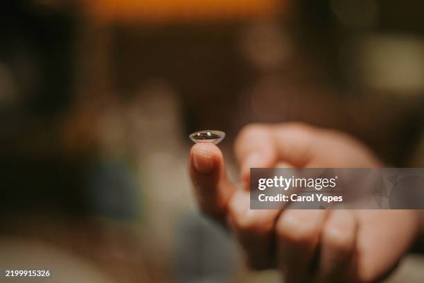 hand holding contact lens - lenti a contatto foto e immagini stock