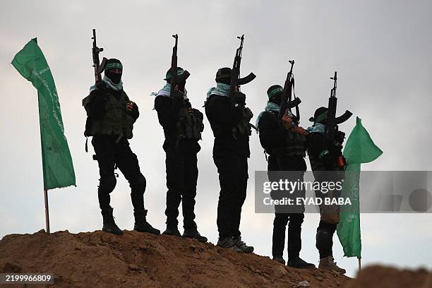 Palestinian Hamas militants gather at the site of the handing over of the bodies of four Israeli hostages in Khan Yunis in the southern Gaza on...