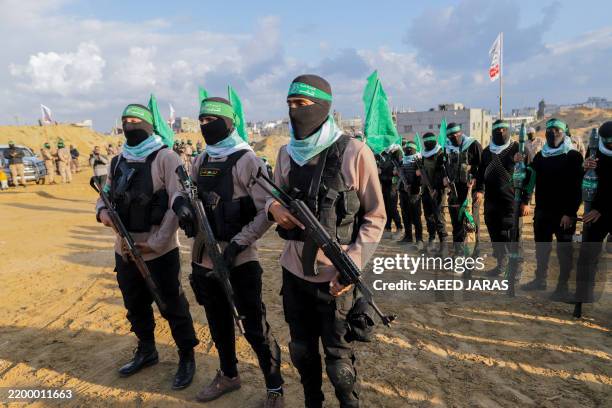 Palestinian Hamas fighters gather at the site of the handing over of the bodies of four Israeli hostages in Khan Yunis in the southern Gaza Strip on...