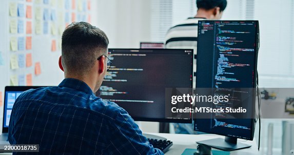 American male software engineer developer use computer work on program coding and data security in office. Artificial intelligence and programming. American male software engineer developer use computer work on program coding and data security in office. Artificial intelligence and programming.
