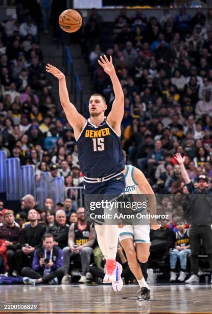 Nikola Jokic of the Denver Nuggets lobs a last-second shot during the third quarter against the Charlotte Hornets at Ball Arena in Denver, Colorado...