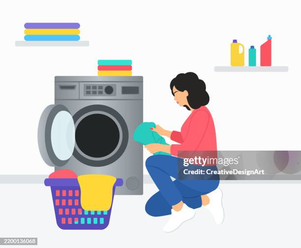 laundry room with close-up of woman loading dirty clothes into washing machine - washing machine stock illustrations