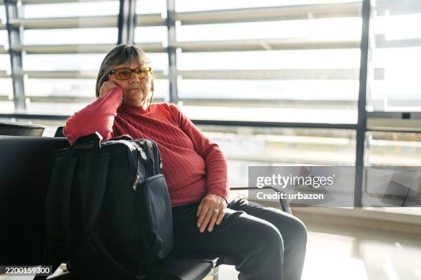 senior woman waiting for her plane at the airport in vienna in austria - só uma mulher idosa imagens e fotografias de stock
