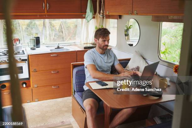 caravan, man and online with laptop for connection, coffee and remote work for journalist on trip. motorhome, male person and blog writer with typing for freelance, news story and tea cup in morning - blogging stock pictures, royalty-free photos & images