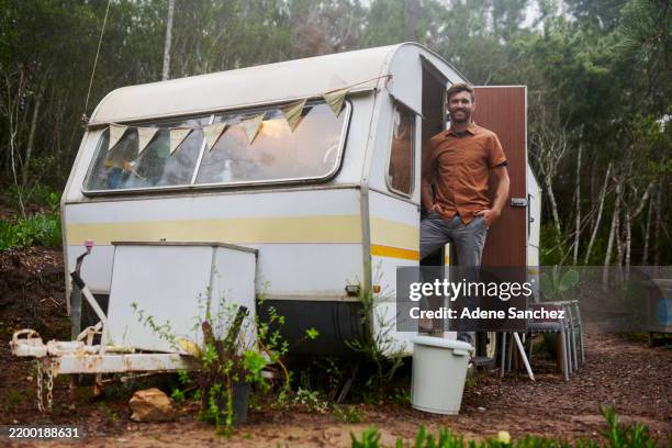 camping, nature and portrait of man by caravan for outdoor adventure, holiday and relax on mountain. trailer park, van and happy person by vehicle for mobile home, travelling and journey in forest - caravan stockfoto's en -beelden
