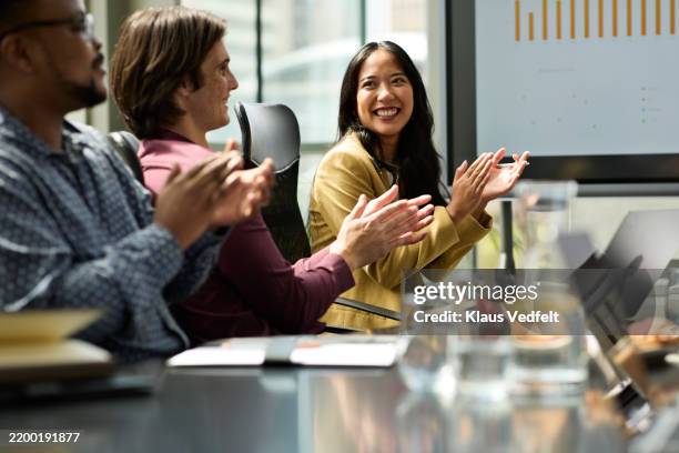 happy businesswoman clapping in meeting room - negócios finanças e indústria - fotografias e filmes do acervo