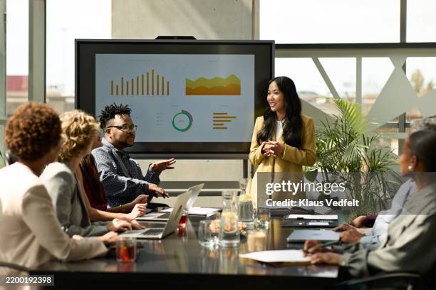 colleagues sharing ideas during team meeting - projection screen stock pictures, royalty-free photos & images